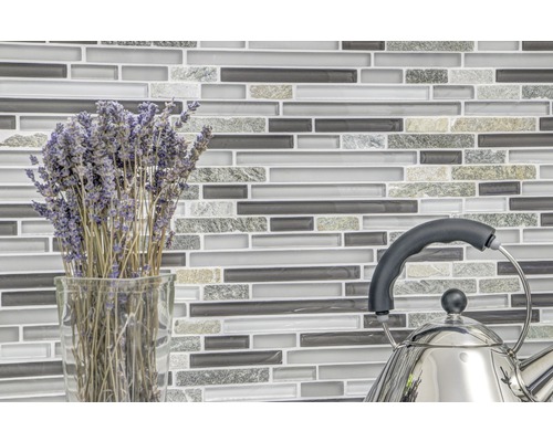 Mosaikplattvägg med lavendelbukett i vas och tekanna