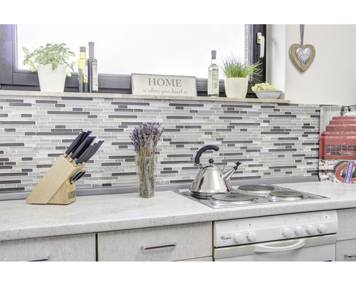 Köksscen med mosaikplattor, kokplatta, diskho och diverse köksredskap