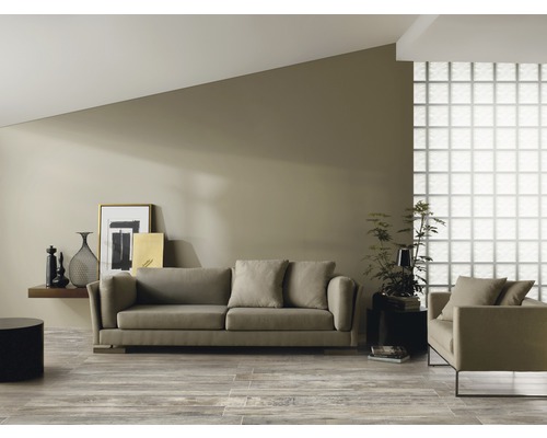 Vardagsrum med soffa, fåtölj, hylla och dekoration på trägolv