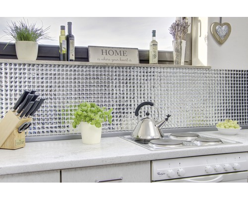 Ljust kök med mosaikplattor, kokplatta, vattenkokare och dekorativa element.