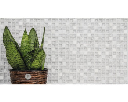 Inomhusväxt i flätad kruka framför mosaikbakgrund