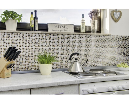 Köksscen med mosaikplattor, spishäll och köksredskap