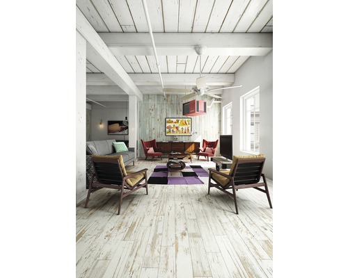 Ljust vardagsrum med trägolv, grå soffa, fåtöljer och TV