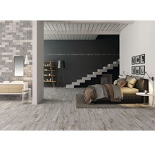 Ljust sovrum och badrum med tvättställ, spegel, trappa, säng och dekoration