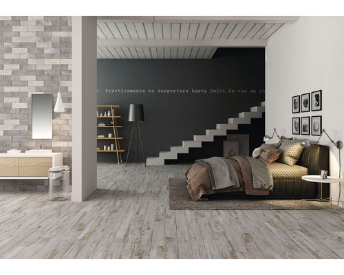 Ljust sovrum och badrum med tvättställ, spegel, trappa, säng och dekoration