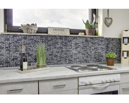 Köksscen med mosaikvägg, spis och dekorationer på bänkskivan.