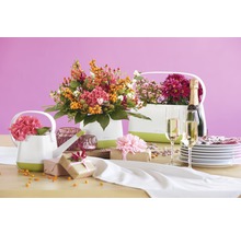 Dekorativt bord med blomsterarrangemang i ytterkrukor, presenter, champagne och porslin