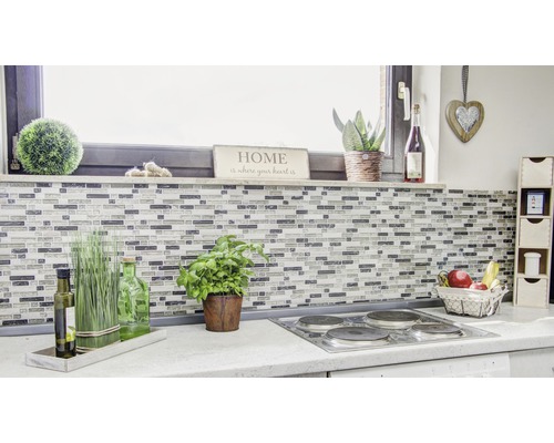 Köksscen med mosaikplattor, örter, dekorationer och elektrisk spis