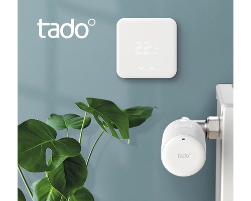 Tado logotyp, väggtermostat och radiatortermostat på en vägg