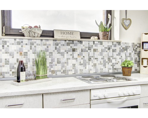 Köksscen med mosaikplattor, spis och dekorativa element för en hemtrevlig atmosfär.