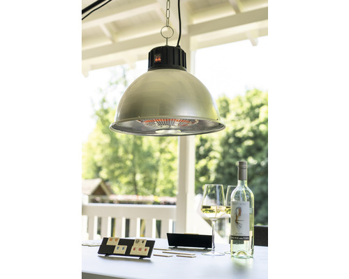 En utomhusscen med en hängande lampa, ett spel, en flaska vin och glas på ett bord