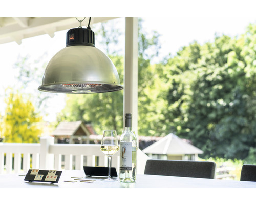 Hänglampa över ett bord med drycker och ett spel utomhus.