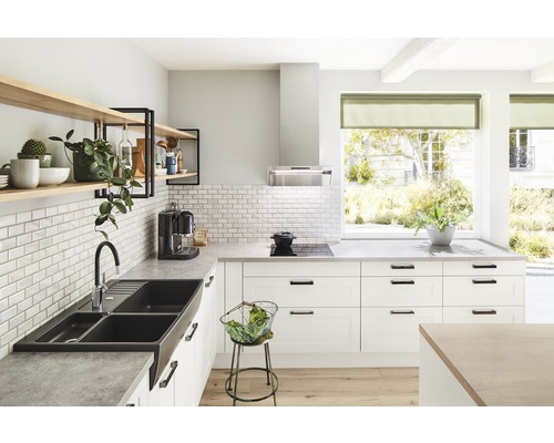 Ljust kök med diskho, kran, hyllor och köksmaskiner.