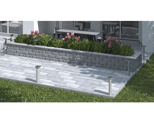 Terrassdesign med gatstenar, stödmur med plantering och solcellslampor