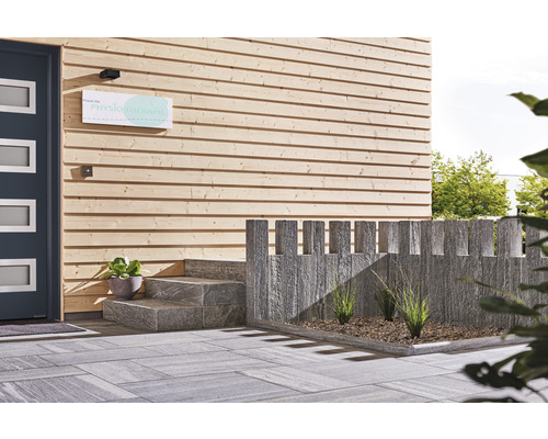 Entré till en byggnad med träfasad, stentrappa och gatsten