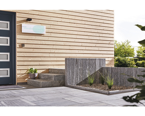 Entré med träfasad, gatsten och trappa