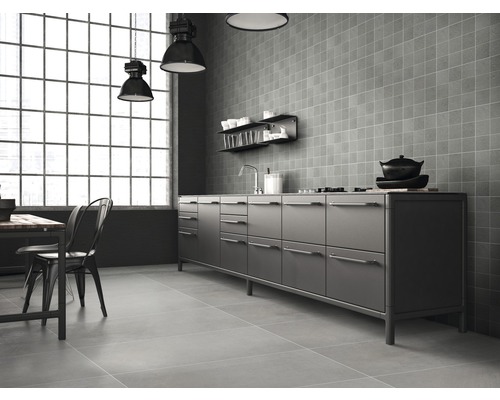 Ljust kök i industriell design med pentry, fyrkantiga väggplattor och matbord