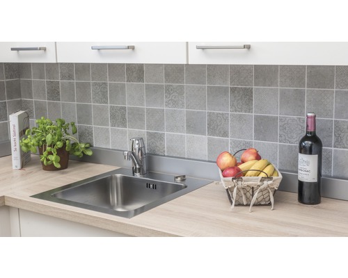 Diskho med kran på en köksbänk med kaklat stänkskydd