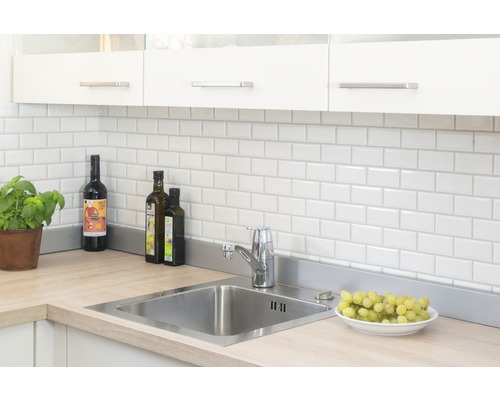 Köksscen med diskho, kran, kakel och köksredskap