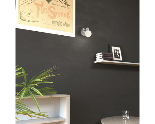 Vardagsrum med vägglampa, hylla och dekoration