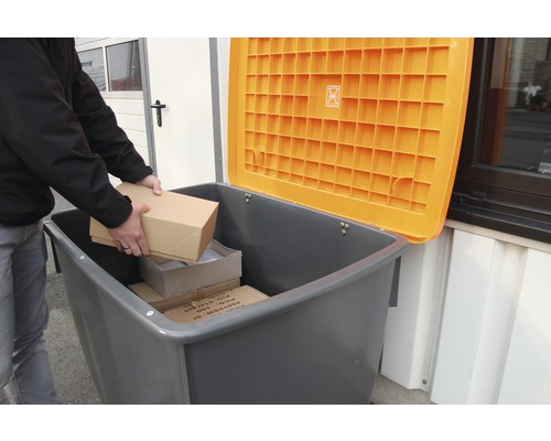 Person lägger paket i en grå återvinningsbehållare med ett öppet, orange lock
