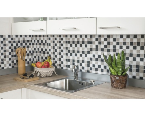 Diskho med blandare, mosaikplattor och köksredskap på en köksbänk