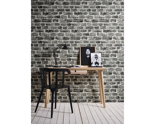 Arbetsrum med skrivbord, stol, lampa och mönstrad tapet