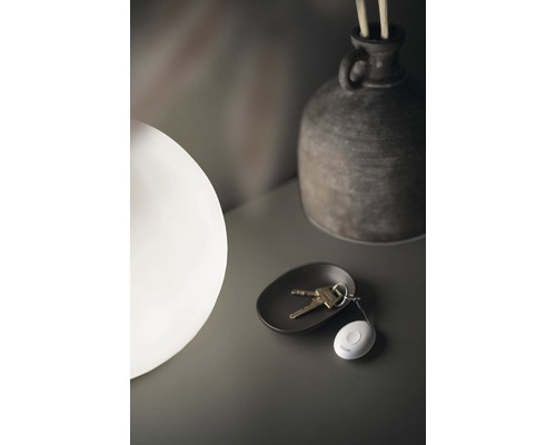 Dekorativ scen med nyckelknippa, skål, lampa och vas