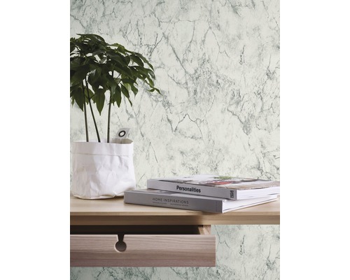 Miljöbild med marmortapet, bord, växt och böcker