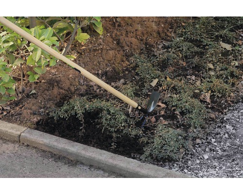 Trädgårdshacka med träskaft som används för jordbearbetning