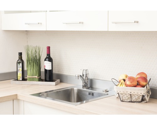 Diskho i rostfritt stål med kran, omgiven av dekoration och mat.