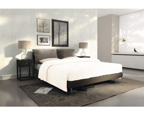 Sovrum med säng, sängbord och dekorativ väggtapet