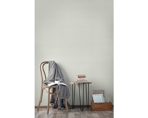 Vardagsrum med stol, filt, böcker, sidobord och fotoramar