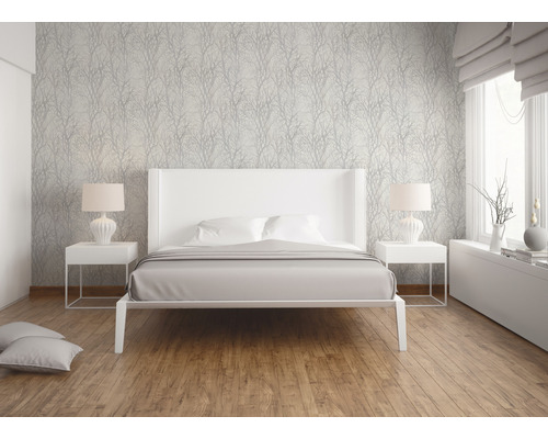 Modernt sovrum med vit säng, sängbord och mönstrad tapet.