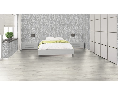 Ljust sovrum med säng, nattduksbord, tapet med trämönster och garderob