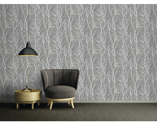 Rumsöversikt med grå tapet med trämotiv, fåtölj och sidobord