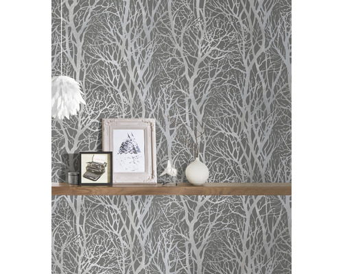 Scen med grå tapet med träddesign och hylla med dekorationer.