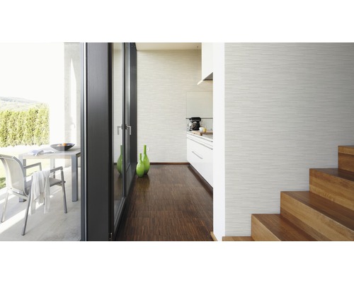 Ljust rum med tapet, trägolv, kök och trappa.