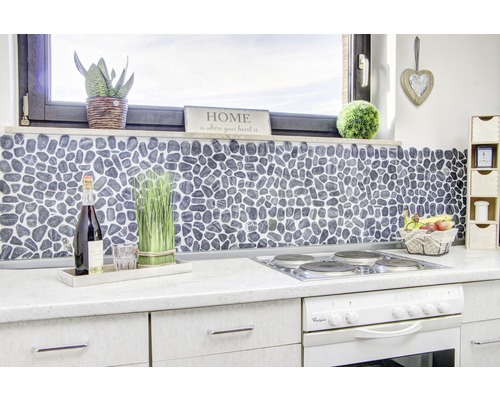 Köksscen med stenmosaikplattor som stänkskydd, dekorationer och elspis.