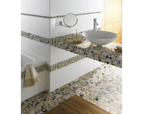 Badrum med handfat, spegel, badkar och golv av stenar