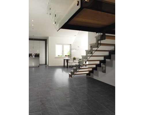Ljust rum med kök, trappa och grått klinkergolv.