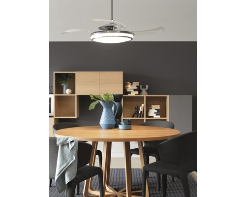 Matsal med runt bord, stolar och takfläkt med belysning