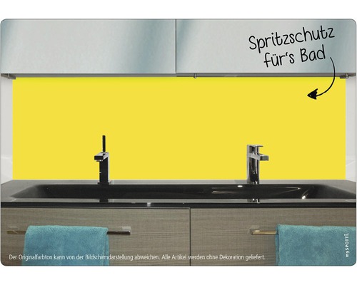 Gult stänkskydd för badrummet bakom ett handfat.