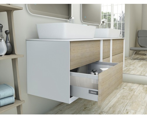 Badrum med tvättställsskåp, bänkskivor och öppet lådsystem.