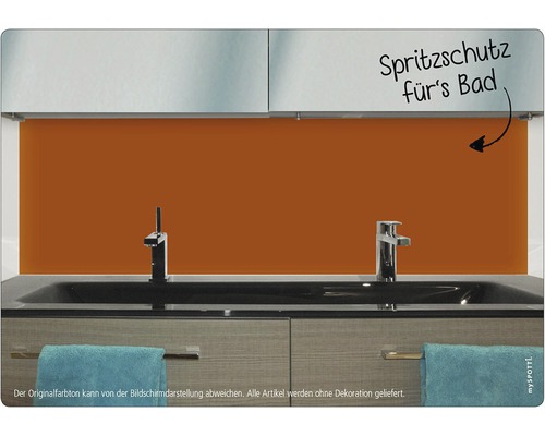 Orange stänkskydd bakom ett handfat i badrummet.