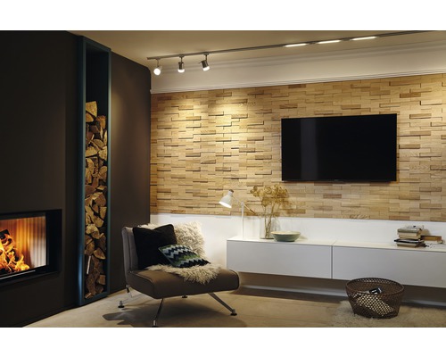 Vardagsrum med öppen spis, vedhylla, fåtölj, TV-vägg och taklampa