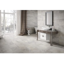 Ljust badrum med klinkergolv, tvättställsskåp och spegel