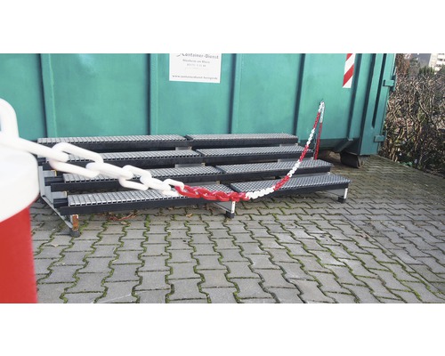 Trappa med rödvit kedja framför container