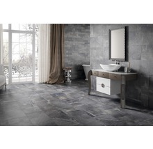 Modernt badrum med grå vägg- och golvplattor, tvättställ och fönster