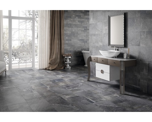 Modernt badrum med grå vägg- och golvplattor, tvättställ och fönster